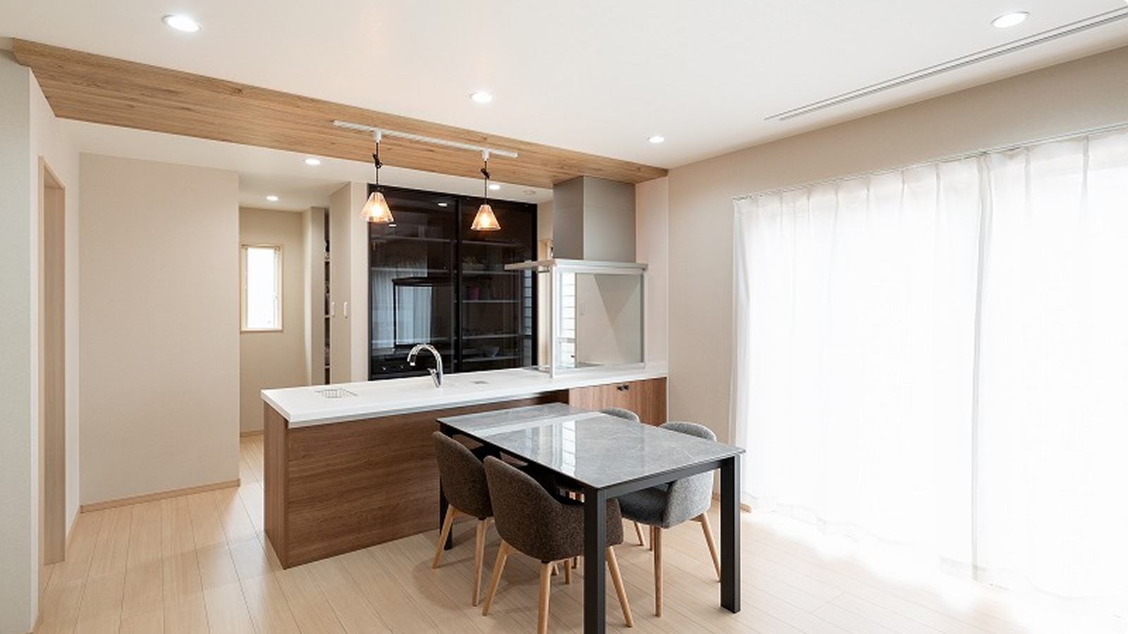 木目の下がり天井と対面キッチンが印象的な明るいダイニングキッチン