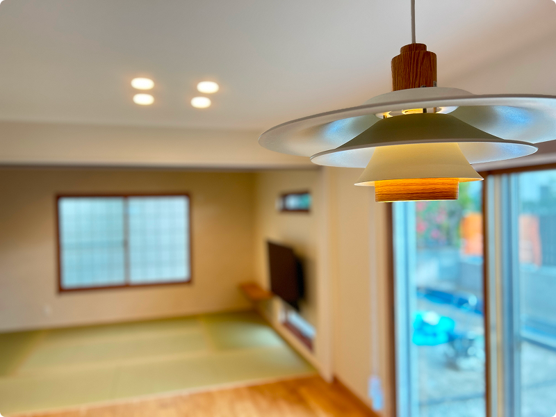 北欧デザインのペンダントライトと畳スペースのあるリビング空間